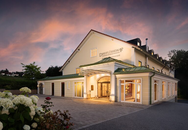 Die Eingangstür des charmanten Hotels Dreiflüssehof in Passau bei stimmungsvoller Nachtbeleuchtung.