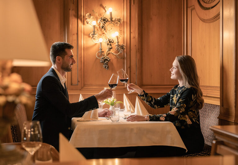Ein Paar genießt den Augenblick bei einem Glas Wein im stilvollen Ambiente des Restaurants Dreiflüssehof.