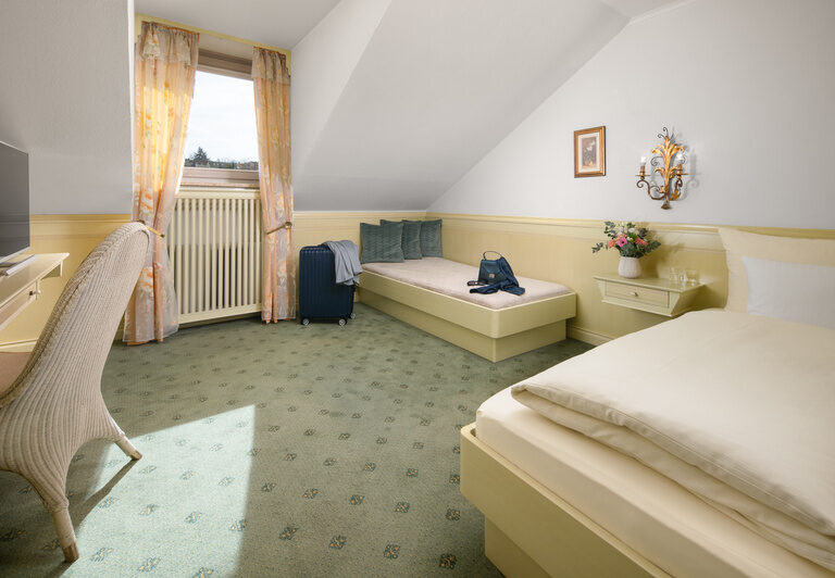 Das gemütliche Familienzimmer des Dreiflüssehofs in Passau lädt mit seiner komfortablen Atmosphäre zum Wohlfühlen ein.