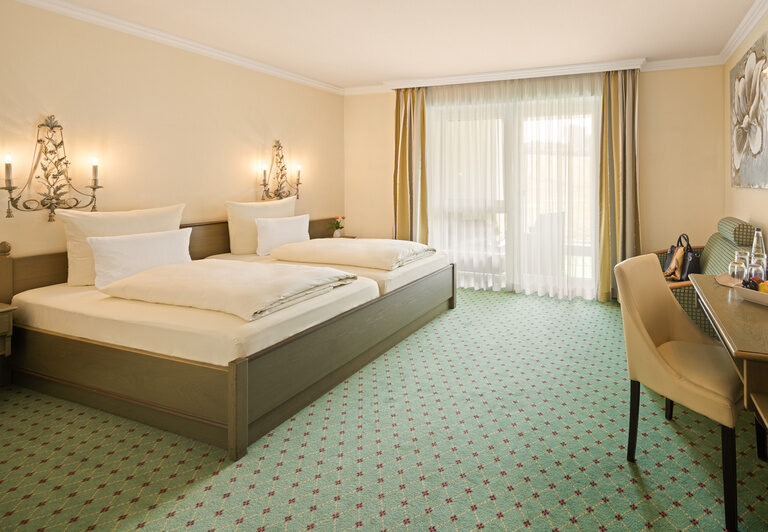 Das stilvolle Schlafzimmer des Classic-Zimmer im Dreiflüssehof lädt zu erholsamen Nächten in behaglicher Atmosphäre ein.